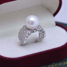 Looking for a timeless piece of pearl jewelry to add to your collection? House of Pearls’ 12-13mm Freshwater Pearl & Large Full CZ Wide Diamond Ring is the perfect classic addition. This ring offers a large 12-13mm freshwater pearl alongside a large full CZ diamond, making it wearable luxury. Celebrate your special moments by wearing this beautiful pearl & diamond ring. White 12-13mm Freshwater Pearl Ring This popular ring design features AAAA quality, round freshwater pearls measuring 12-13mm. Pearl White Diamond Pearl Ring With Drop Detail, Pearl White Diamond Ring With Pearl Drop, White Gold Pearl Ring With Pearl Drop, Luxury White Rings With Pearl Drop, Elegant White Pearl Ring With Charm, Elegant White Gold Pearl Ring, Luxury Akoya Pearl Ring For Anniversary, Fine Jewelry Pearl Open Ring, Luxury Akoya Pearl Ring In Diamond White