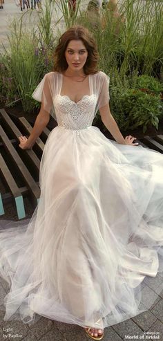 a woman in a white dress sitting on a bench