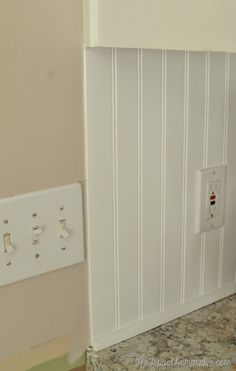 a white light switch sitting on the side of a wall next to a counter top