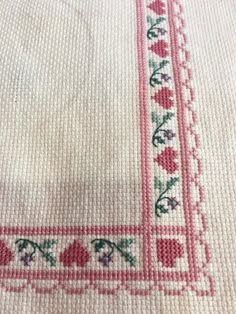 a close up of a cross stitched table cloth