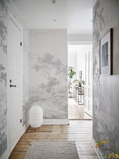 a hallway with wallpaper and rugs on the floor