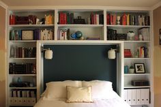 a bed with bookshelves behind it and a green pillow on the headboard