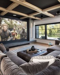 a large living room with couches and a big screen tv on the wall in front of it