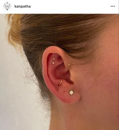 a woman's ear is shown with two piercings