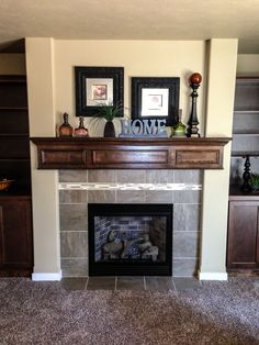 a living room with a fire place and bookshelves on the wall above it