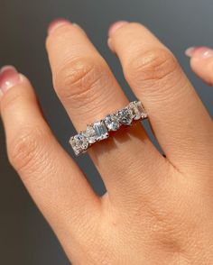 a woman's hand with a diamond ring on top of her finger, showing the band