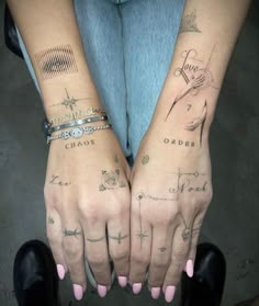 two hands with different tattoos on them