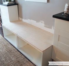 a white shelf sitting on top of a wooden floor next to a dresser and rug