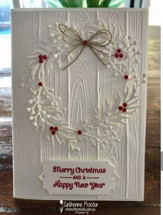 a christmas card made with white paper and red berries