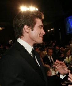 a man in a suit and tie standing next to another man at a formal event