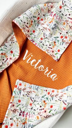 an orange and white flowered shirt with the name victoria on it