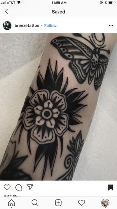 a close up of a person's arm with a butterfly and flower tattoo on it