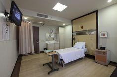 an empty hospital room with a bed and television