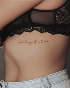 a woman's stomach with the words, one day at a time written on it