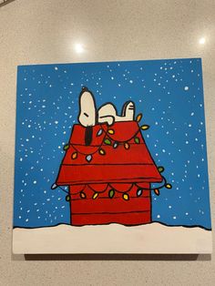 a painting of two dogs sitting on top of a red box with christmas lights around it