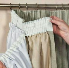 a woman's hand is pulling out the top of her pants from behind a curtain