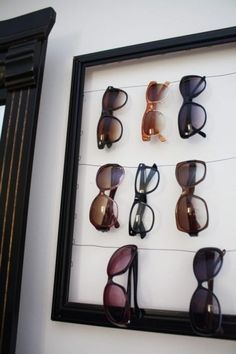 there are many pairs of sunglasses on display in the frame with glasses attached to it