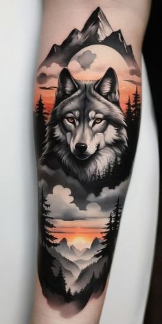 a tattoo with a wolf on it's leg and mountains in the background at sunset