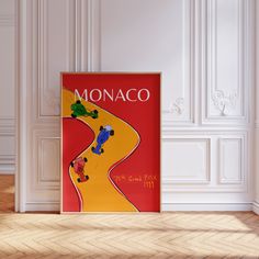 there is a poster on the wall in the room that says monaco with cars driving down the road