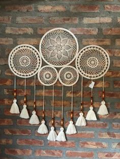 a wall hanging with white tassels and wooden beads on it's sides