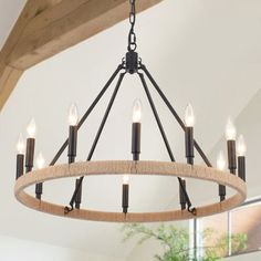 a chandelier hanging from a wooden beam in a room with white walls and wood beams