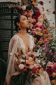 a woman sitting on a chair with flowers around her