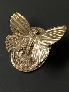 a gold brooch with a butterfly on it