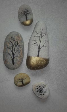 three rocks with trees painted on them