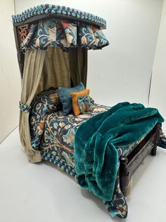 a bed that is made up with blue and green decor on it's sides