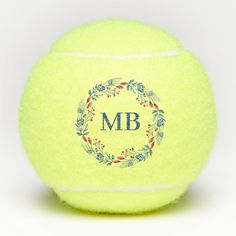 a yellow tennis ball with the monogrammed m b on it's side