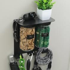 a black shelf with various items and a potted plant next to it on the wall