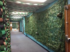 the hallway is decorated with green plants and ribbons hanging from the ceiling, along with carpeted walls