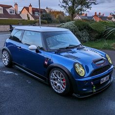 a small blue car parked in a parking lot