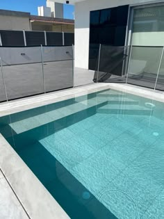 an empty swimming pool in the middle of a building with glass doors on it's sides