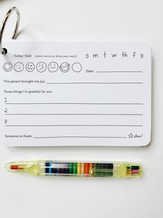 a notepad with some crayons on it next to a pair of glasses