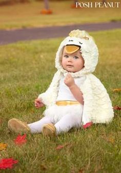 a baby sitting in the grass wearing a costume