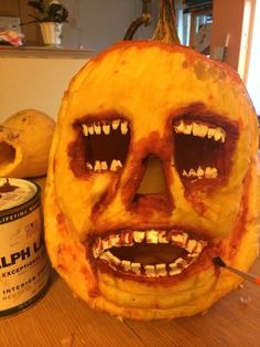 a pumpkin that has been carved to look like a face with teeth and fangs on it