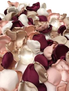 many different colors of fabric petals on a white table top with one flower in the middle