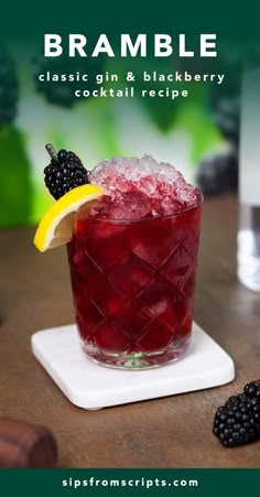 a glass filled with blackberries and a lemon wedge