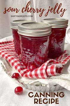 three jars filled with cranberry jelly sitting on top of a red and white checkered cloth