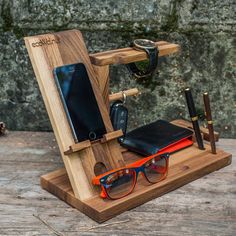 a wooden stand with glasses, cell phone and pen