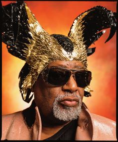 an older man wearing sunglasses and a golden headdress