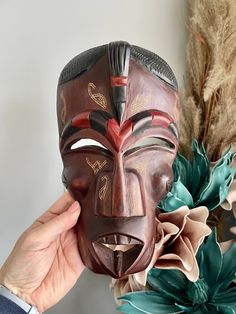 "Wonderful wood tribal mask made in Kenya with beautiful hand carved detailing is a perfect wall hanging to add to your home decor. It is an intricate, colorful design carved into solid wood measuring 9 1/2\" by 5 1/4\"." Vintage Mask, Wooden Mask, Mask Wall, Vintage Hair Clips, Green Business, Animal Designs, African Culture, The Mask, Unique Animals