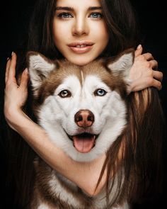 a woman holding a husky dog in her arms