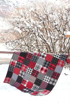 a blanket hanging from a tree in the snow