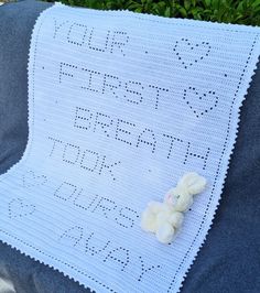 a teddy bear laying on top of a crocheted blanket