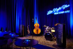 the stage set up for an event with musical instruments and sound equipment in front of blue curtains