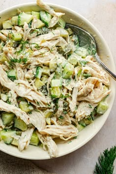 a white bowl filled with shredded chicken salad