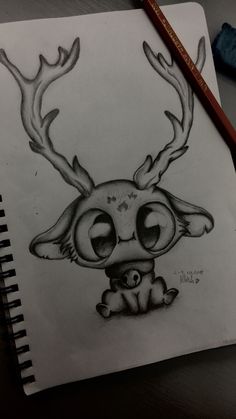 a drawing of a deer with antlers on it's head, sitting next to a pencil