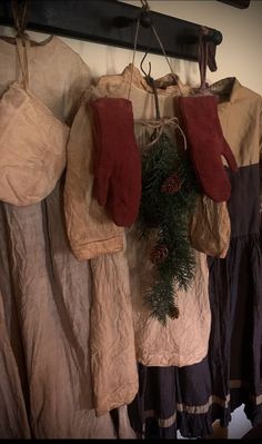 christmas stockings hanging from the clothes line with pine cones and red mittens on them